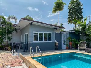 a house with a swimming pool in front of it at Thawat Villa Boutique Resort in Ko Lanta