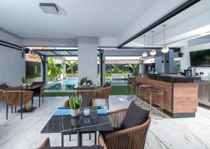 an open kitchen and dining room with tables and chairs at Captain Napoleon Paterakis CNP Luxurious Suites in Heraklio