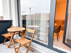 une table et deux chaises sur un balcon dans l'établissement Julia Airport Apartment With Parking, à Someşeni