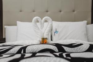 two white swans sitting on top of a bed at Hotel Flamingo Merida in Mérida