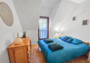 a bedroom with a blue bed and a window at Maison paisible avec jardin à Houlgate in Houlgate
