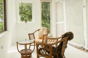 a room with chairs and a table and windows at Quiet Hideaway Surrounded By Nature in Vesterborg