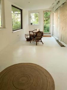 a living room with a rug on the floor and windows at Quiet Hideaway Surrounded By Nature in Vesterborg