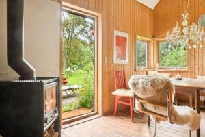 a living room with a fireplace and a dining room with a table at Quiet Hideaway Surrounded By Nature in Vesterborg +13 photos