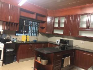 a kitchen with wooden cabinets and a black counter top at Family Home In Maun in Maun +16 photos