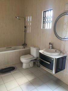 a bathroom with a toilet and a sink and a mirror at Family Home In Maun in Maun