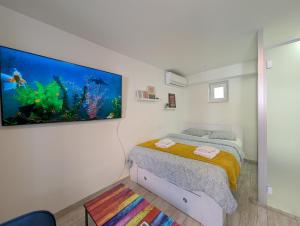 a bedroom with a bed and an aquarium on the wall at Secluded Studio in Central Sesvete in Sesvete