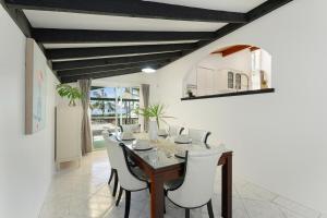 a dining room with a wooden table and white chairs at Casula cozy 3Br home with parking & WiFi 