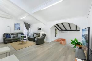 a living room with two couches and a table at Casula cozy 3Br home with parking & WiFi 