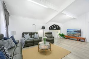 a living room with a couch and a table at Casula cozy 3Br home with parking & WiFi 