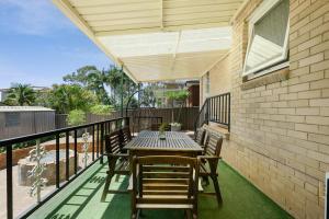 a patio with a table and chairs on a balcony at Casula cozy 3Br home with parking & WiFi 