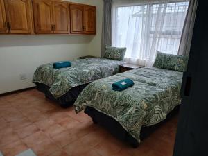 Un dormitorio con dos camas y una ventana en 41 on Clarendon, en Graskop