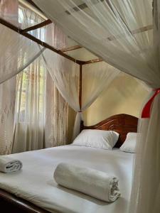 a canopy bed with a towel laying on it at Kurundu House Mirissa in Mirissa