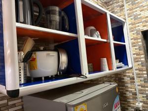 a kitchen cabinet with a coffee maker and a mixer at Nabs lodge in Kumasi