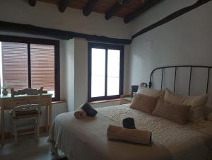 1 dormitorio con 1 cama, 1 silla y 2 ventanas en Las Golondrinas, en Galaroza