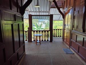 een hal van een huis met een tafel op een veranda bij Nur Nur House in Ban Nong Chaeng