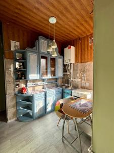 a kitchen with blue cabinets and a table at Corner Guest House in Tbilisi City