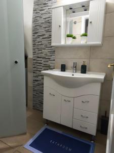 a bathroom with a sink and a mirror and a blue floor at Maria’s apartment in Amfilochía