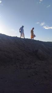 梅尔祖卡Merzouga camp的两个人背着背包走上山