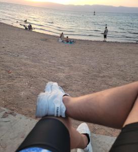 a person sitting on the beach with their leg in the air at aqaba Almahdud in Aqaba