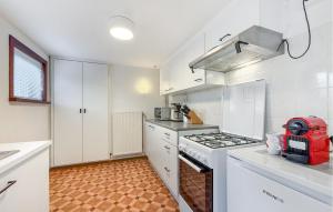 a kitchen with white cabinets and a stove top oven at 1 Bedroom Nice Apartment In De Panne in De Panne