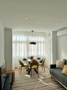 a dining room with a table and chairs and a couch at JC Apartments in Amadora
