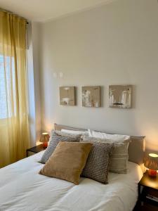 a bedroom with a white bed with three mirrors on the wall at JC Apartments in Amadora +37 photos