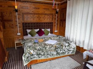 a bedroom with a large bed with wooden walls at Himalayan Pine Majesty in Jibhi