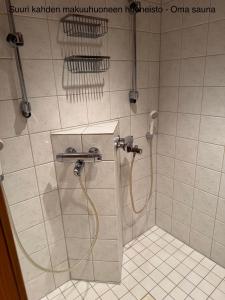 een douche met een slang in de badkamer bij Messner Tahko in Tahkovuori +50 foto's