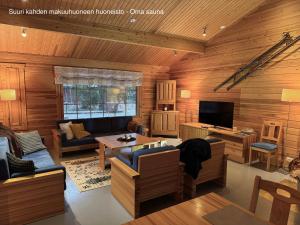 a living room with wood paneled walls and a television at Messner Tahko parimökki - Saunallinen ja saunaton huoneisto - in Tahkovuori