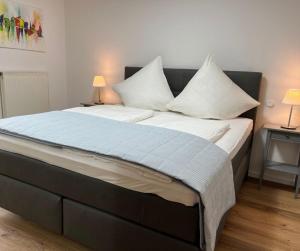a bed with white sheets and pillows in a room at Ferienhaus Wacholderbeere in Winsen