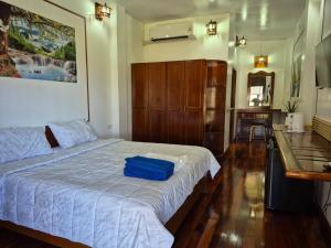 een slaapkamer met een bed met een blauwe tas erop bij Nur Nur House in Ban Nong Chaeng