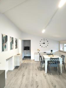 ein weißer Raum mit Tisch und Stühlen und einer Küche in der Unterkunft Sweet Home Longarone in Longarone