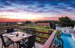 a table and chairs on a balcony with a pool at House Ivica in Banjole
