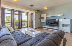 a living room with a blue couch and a tv at House Ivica in Banjole