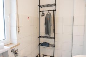 a bathroom with a shower with a coat on a rack at Kaisercity Apartment 2 in Nuremberg