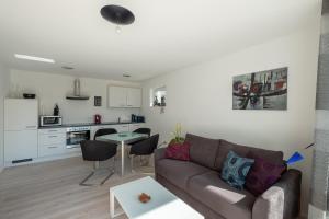 a living room with a couch and a kitchen at Ferienwohnung Wellenreiter mit ruhigem Garten in Überlingen