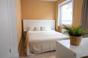 a bedroom with a white bed with a plant on it at Kaisercity Apartment 2 in Nuremberg