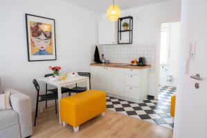 a small kitchen with a table and a yellow chair at Kaisercity Apartment 2 in Nuremberg