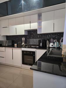 a kitchen with white cabinets and a black counter top at Matanak 2 in Munyonyo