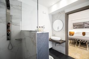 a bathroom with a shower and a sink and a bed at Talìa Rooms and Gallery in Messina