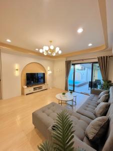 ein Wohnzimmer mit Sofa und Fernseher in der Unterkunft New Love Is Pool Villa, Modern 3BR Pool Villa Cozy Style in Nathon Bay + 38 Fotos