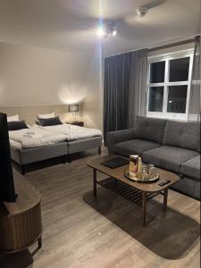 a living room with a couch and a bed at Hotell Gamla Staden in Kalix