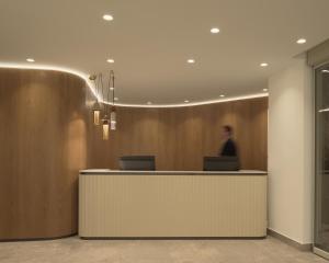 a man standing at a reception desk in a lobby at Galaxy Suites Boutique Resort in Hersonissos +57 photos