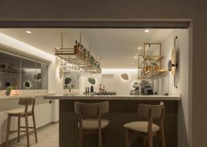 a kitchen with a bar with stools in it at Galaxy Suites Boutique Resort in Hersonissos