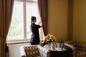 布尔诺格兰迪萨豪华宫殿酒店的女人从窗口看出来