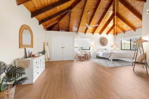 a large living room with wooden ceilings and a room with a couch at Holiday Retreat Jervis Bay - 5 Min Walk to Bay in Callala Bay