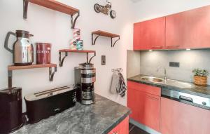 a kitchen with red cabinets and a coffee maker on a counter at Amazing Apartment In De Haan With Wifi in Mispelburg