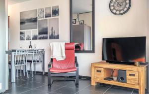 a living room with a red chair and a tv at Amazing Apartment In De Haan With Wifi in Mispelburg