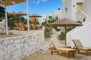 eine Gruppe von Stühlen und Sonnenschirmen auf einer Terrasse in der Unterkunft Blue Pulse JR- Villas - Korifi Suites Chersonisos in Iraklio